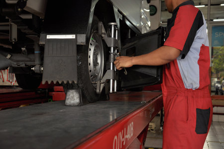 A Car on the Car Steering Wheel Balancer and Calibrate with laser reflector attach on each tire to center driving adjust in the garageのeditorial素材