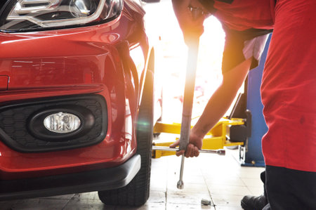A Car on the Car Steering Wheel Balancer and Calibrate with laser reflector attach on each tire to center driving adjust in the garageのeditorial素材
