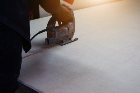 Male builder using wood cutting circular saw machine in workshopのeditorial素材