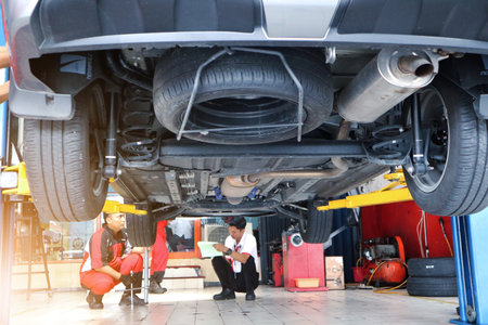 mechanics repairing car in garage under the car.のeditorial素材