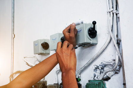 Electrician working safely on switches and sockets of a residential electrical systemのeditorial素材