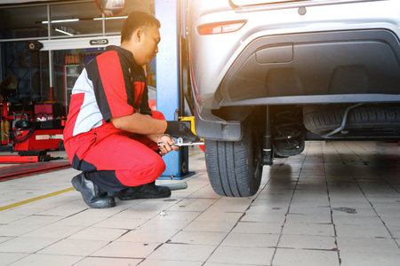 Car repairs. Replacing wheels. Seasonal tire replacement. The master removes the wheel with both hands with the keyのeditorial素材