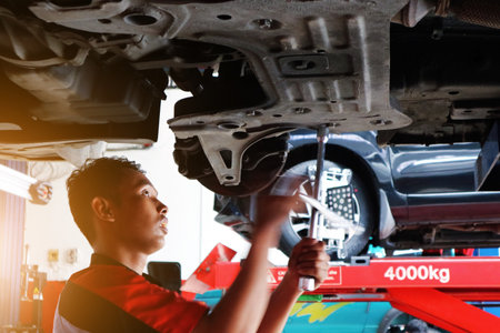 One mechanics repairing car in garage under the car.のeditorial素材