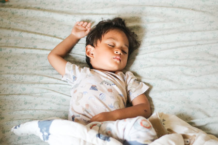 Top View of Asian boy having sweet dreams while Sleeping Cozily a Bed in bedroom at home. bedtime, healthy sleep habits conceptの写真素材