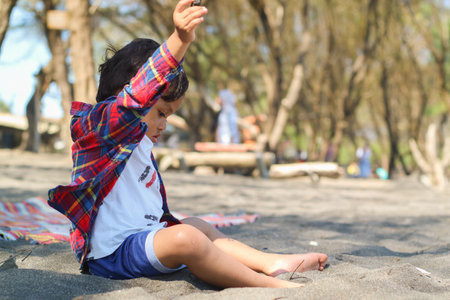Happy kids have fun in sea surf on black sand beach. Children sit in seashore. Travel lifestyle, swimming activities in family summer camp. Vacations on tropical island.の写真素材