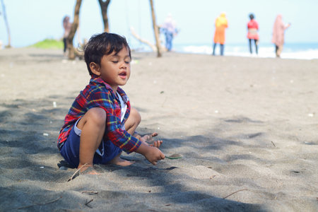 Happy kids have fun in sea surf on black sand beach. Children sit in seashore. Travel lifestyle, swimming activities in family summer camp. Vacations on tropical island.の写真素材
