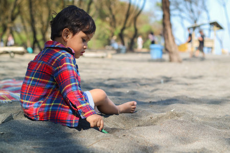 Happy kids have fun in sea surf on black sand beach. Children sit in seashore. Travel lifestyle, swimming activities in family summer camp. Vacations on tropical island.の写真素材