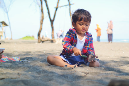 Happy kids have fun on the sand beach. Children sit in the seashore. Travel lifestyle, swimming activities in family summer camp. Vacations on tropical island.の写真素材