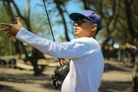 Mature man fishing on beachの写真素材