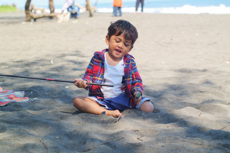 Happy kids have fun in sea surf on black sand beach. Children sit in seashore. Travel lifestyle, swimming activities in family summer camp. Vacations on tropical island.の写真素材