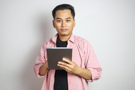 Shot of a young asian businessman working on his tablet in the office