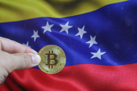 Bitcoin BTC on stack of cryptocurrencies with Venezuela flag in background. The cryptocurrency coin is golden and in focusの写真素材