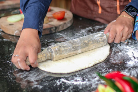 Woman hands rolling dough on kitchen tableの写真素材