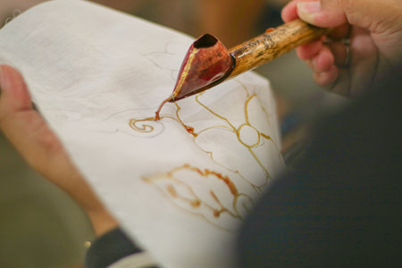 A woman is making batik. Batik is a traditional Indonesian cloth which is the ancestral heritage of the Indonesian peopleの写真素材