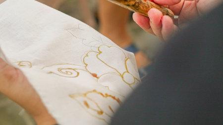 A woman is making batik. Batik is a traditional Indonesian cloth which is the ancestral heritage of the Indonesian peopleの写真素材