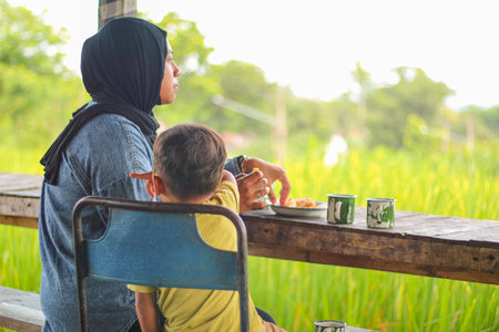 Happy cheerful Asian muslim family stay together in weekend with traditional food and drink, Beautiful Asian woman muslim and lovely little boy portrait and looking at camera.の写真素材