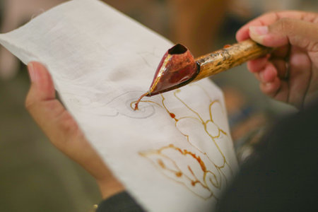 A woman is making batik. Batik is a traditional Indonesian cloth which is the ancestral heritage of the Indonesian peopleの写真素材