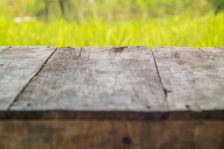 Wooden old table on rice field and cloud background. For your product placement or montage with focus to the table top in the foreground. Empty wooden brown shelf.の写真素材