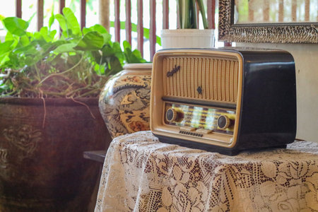a stylish retro radio player stands on a wooden table. daylight from the window. copy spaceの写真素材