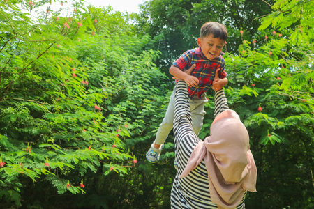 Young mother with her little boy in the park on a beautiful summer dayの写真素材