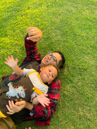 Asian father and son having fun outdoors in the meadowの写真素材