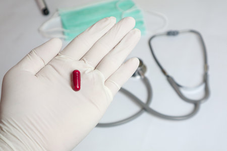 Close up older retired woman taking medicine capsules out of glass bottle. Middle aged elderly grandmother holding vitamins or painkiller antidepressant antibiotic pills in hands, healthcare concept.の写真素材