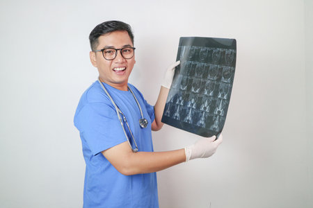 medicine, pet and healthcare concept - middle aged male veterinarian doctor looking at animal's x-ray over blue backgroundの写真素材