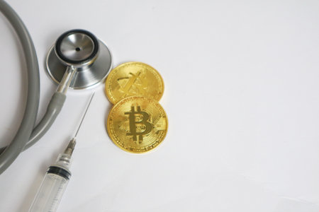 Gold bitcoin with stethoscope checkup on white background Health care, life insurance travel hospitality bitcoins block chain technology conceptの写真素材