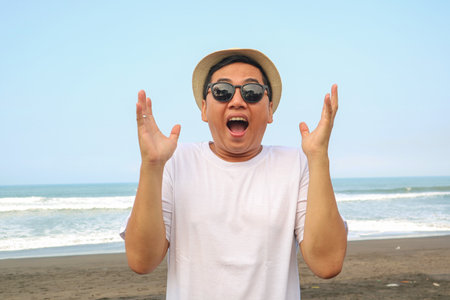 Happy Asian man on the sunny summer beach.の写真素材