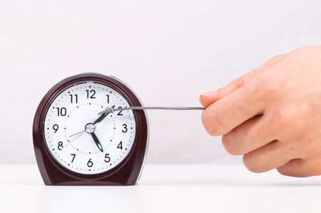 Hand pulling clock hand forwardの写真素材