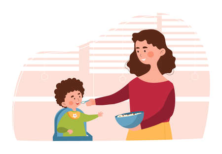 Young mother is feeding her little son in high chair in the kitchenのイラスト素材