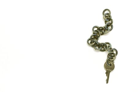 Small Key with a chain on a yellow backgroundの写真素材