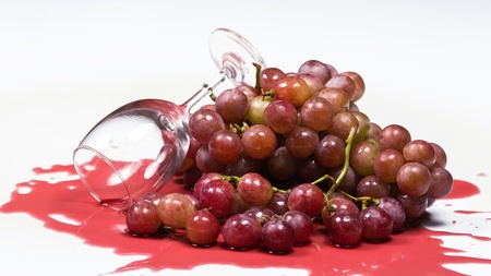Red Wine in glass and red grapes on white backgroundの写真素材
