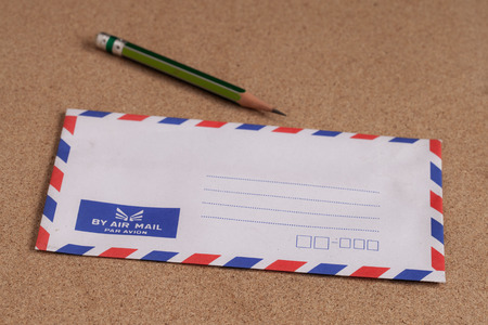 envelope and pencil on wooden background 