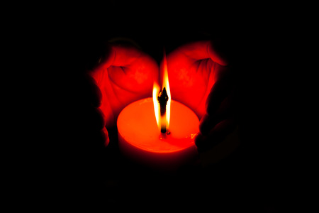 hands holding a burning candle.の写真素材