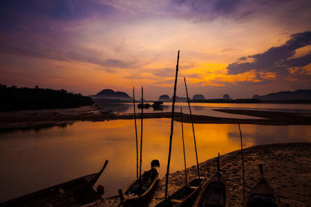 Silhouette of fisherman and traditional thai boats at sunset beach.Sam chong Tai, Phangnga Pprovince.の写真素材