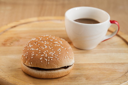 hamburgers and cup of black coffee on wooden board.の写真素材