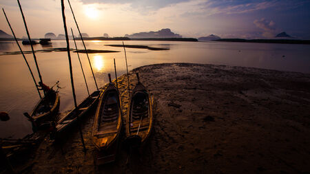 Silhouette of fisherman and traditional thai boats at Sam chong Tai, Phangnga province.の写真素材
