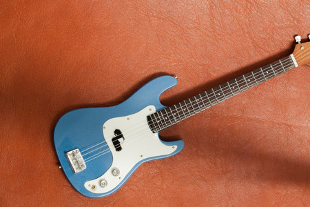 Bass Guitar onb rown leather texture as vintage background.の写真素材