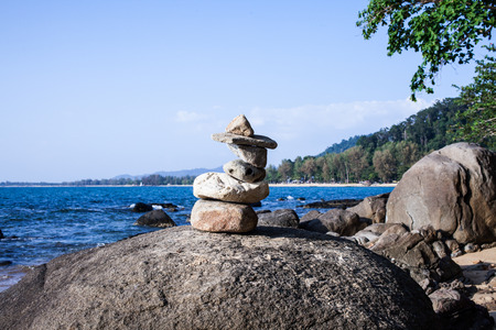 Stack of pebbles on a big rock at the beach.の写真素材