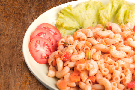 Fried macaroni with egg,chicken and vegetable in tomato sauce.の写真素材