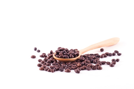 Spread coffee seeds on wooden spoon isolated on white background.の写真素材