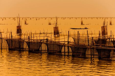 silhouette of fishermen with thier boats fishing in the lake.