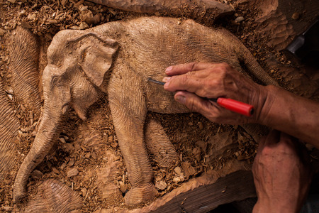 The close up carver or engraver are doing handicraft wooden elephant.のeditorial素材