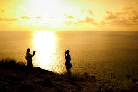 Silhouette of Couple Friends at Prom Thep Cape the Best in Phuket South of Thailand.