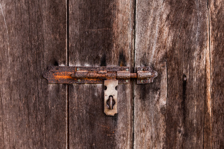 dusty bolt on grungy old wooden door.