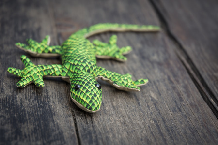 Closeup of a plush gecko on an old wooden tableの写真素材