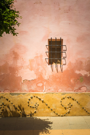Grilled window at the facade of a nicely ornamented wall in a town in Majorca, Spainの写真素材