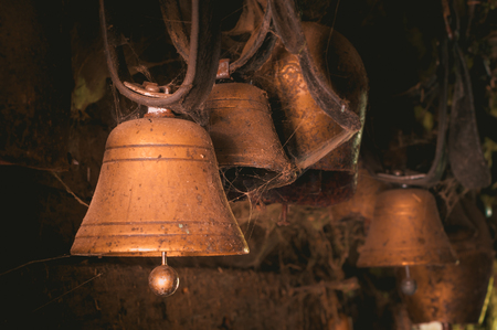Old cowbells hanging in a dirty barnの写真素材
