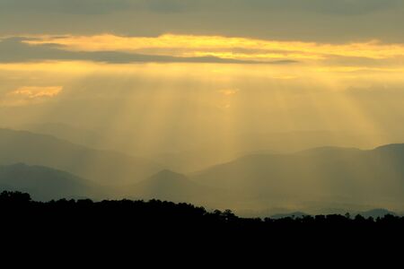 Sun shining through thick cloudy sky, silver lining 